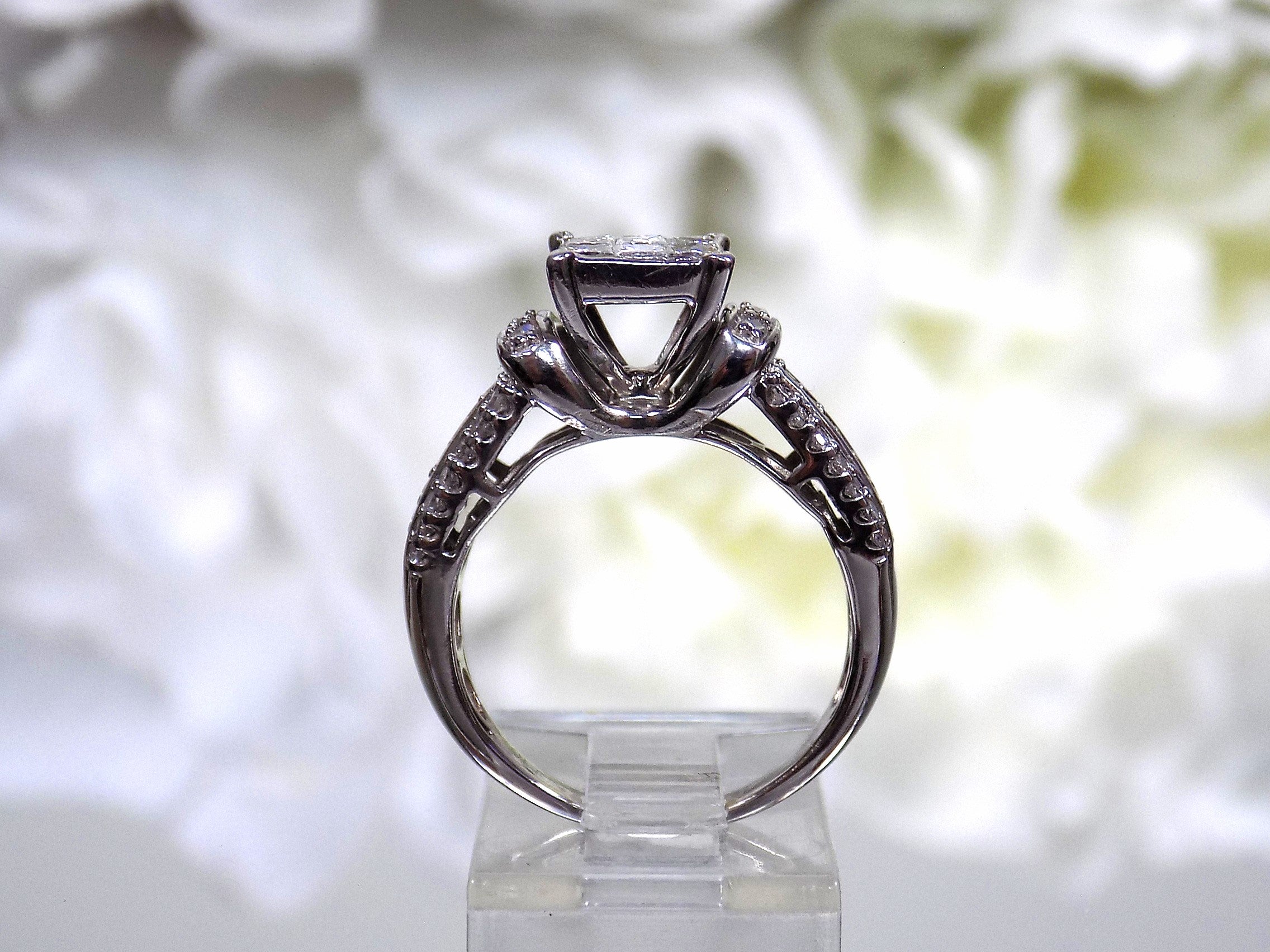This is a side view of an Estate ring with 1.00ct total weight invisible set diamond ring with natural princess cut and round diamonds in white gold.