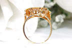 This is a side view of a women's US $1 gold coin ring dated 1853 and set in 14K yellow gold in great condition shown with a white background.