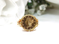 This is a women's US $1 gold coin ring dated 1853 and set in 14K yellow gold in great condition shown with a white background.