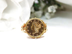 This is a women's US $1 gold coin ring dated 1853 and set in 14K yellow gold in great condition shown with a white background.