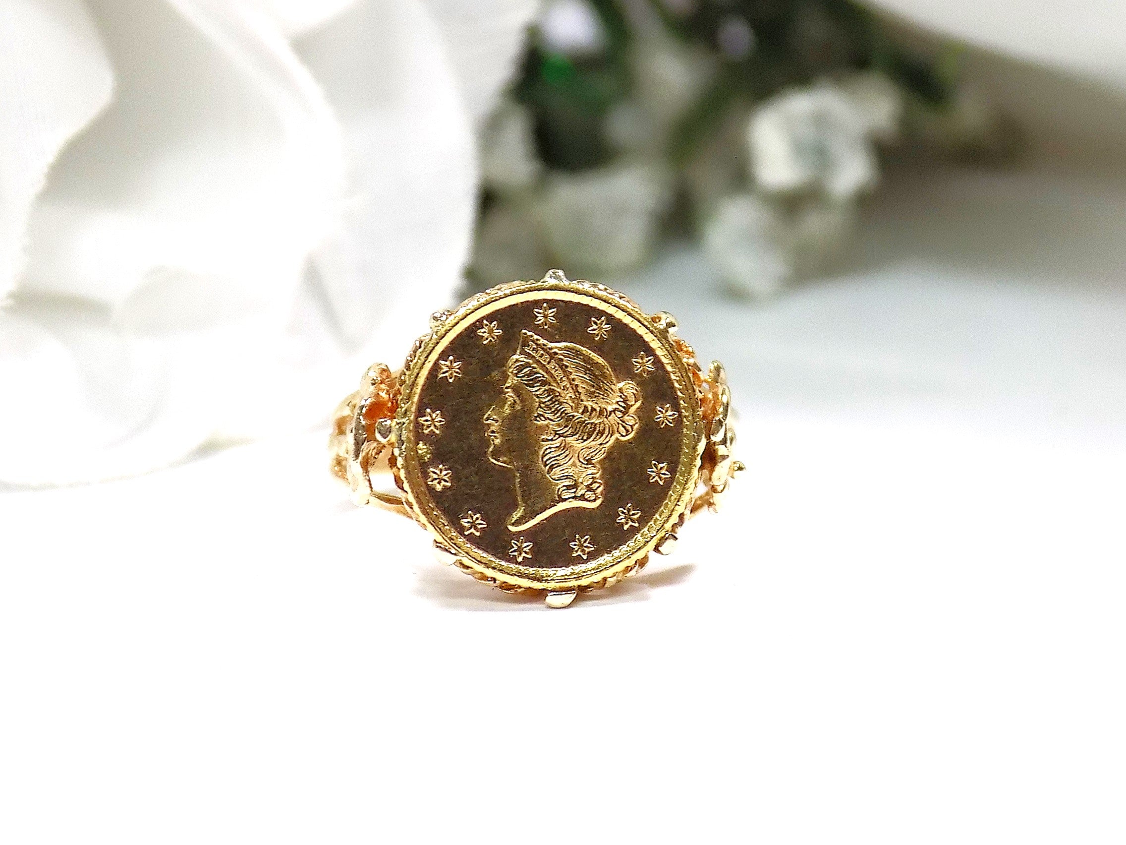 This is a women's US $1 gold coin ring dated 1853 and set in 14K yellow gold in great condition shown with a white background.