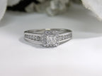 This is a halo style .50ct total weight natural princess cut diamond ring in white gold with white background.