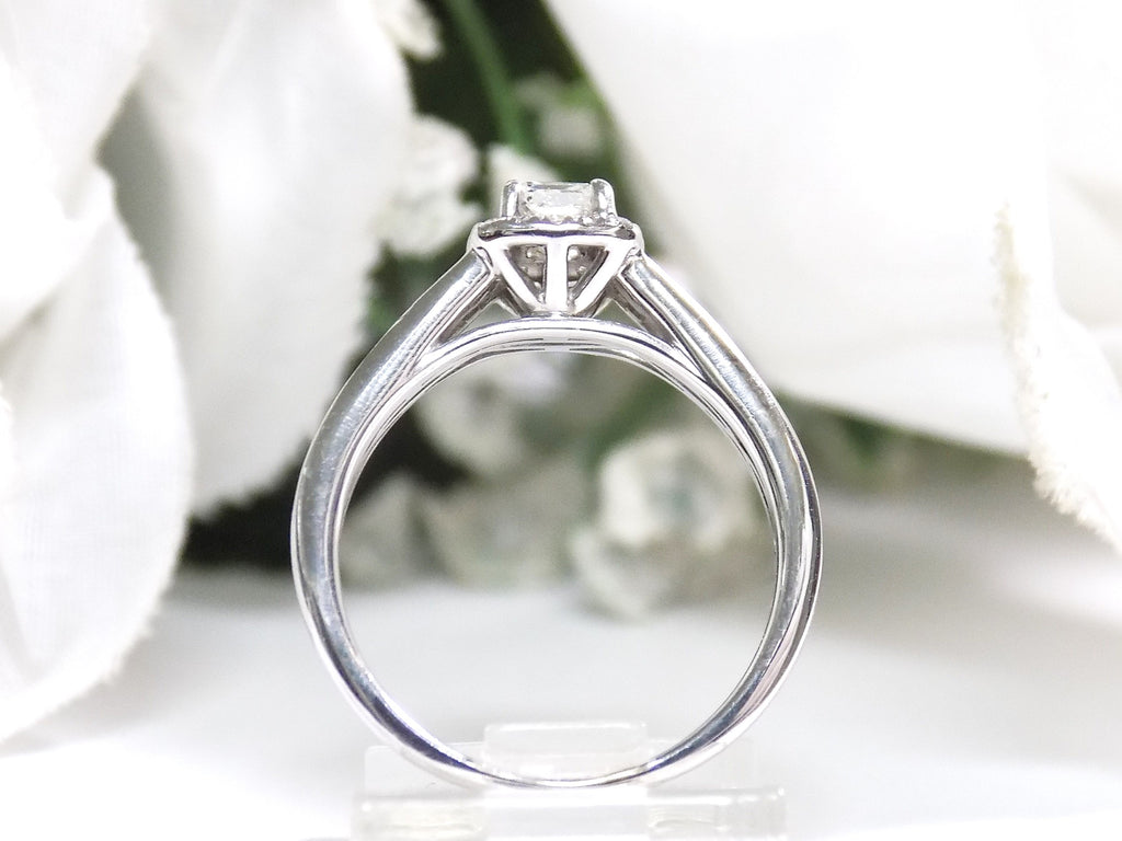 This is a side view halo style .50ct total weight natural princess cut diamond ring in white gold with white background.