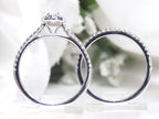 This is a side view of a .73ct total weight 2-piece halo style oval shape natural diamond wedding set with engagement ring and matching band in white gold with a white background.
