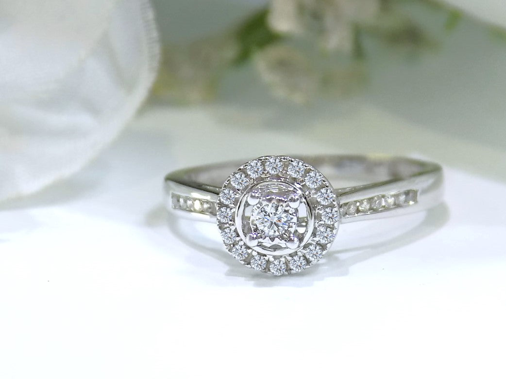 Ladies' halo style small round diamond ring in white gold.