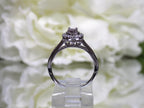 This is a side view of a ladies' halo style small round diamond ring in white gold.