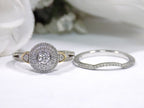 2 rings engagement ring and matching band halo style in diamonds and white gold sitting side by side on white background.