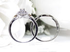 This is a halo style 2-piece wedding set ring with matching band in white gold with yellow gold accents shown from the side on a white background.
