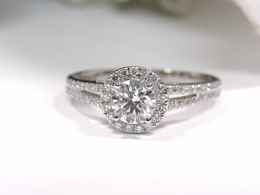 Halo style natural diamond ring in white gold with white background.