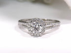 Halo style natural diamond ring in white gold with white background.