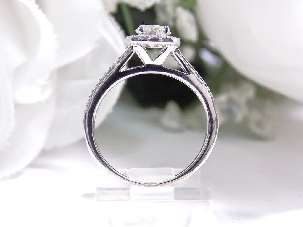 Halo style natural diamond ring in white gold with white background shown from the side.
