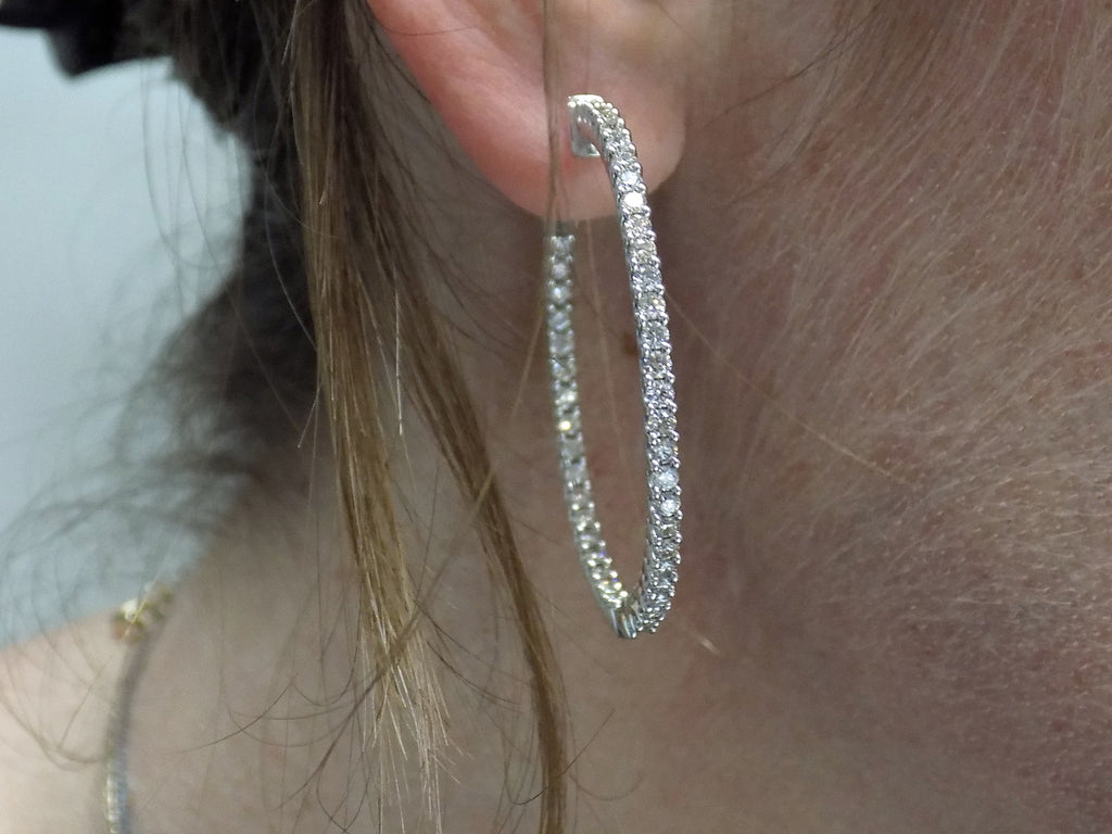 These are very large 1 1/2" in diameter 2.00ct round brilliant diamond hoop earrings in 14K white gold in a ladies ear.