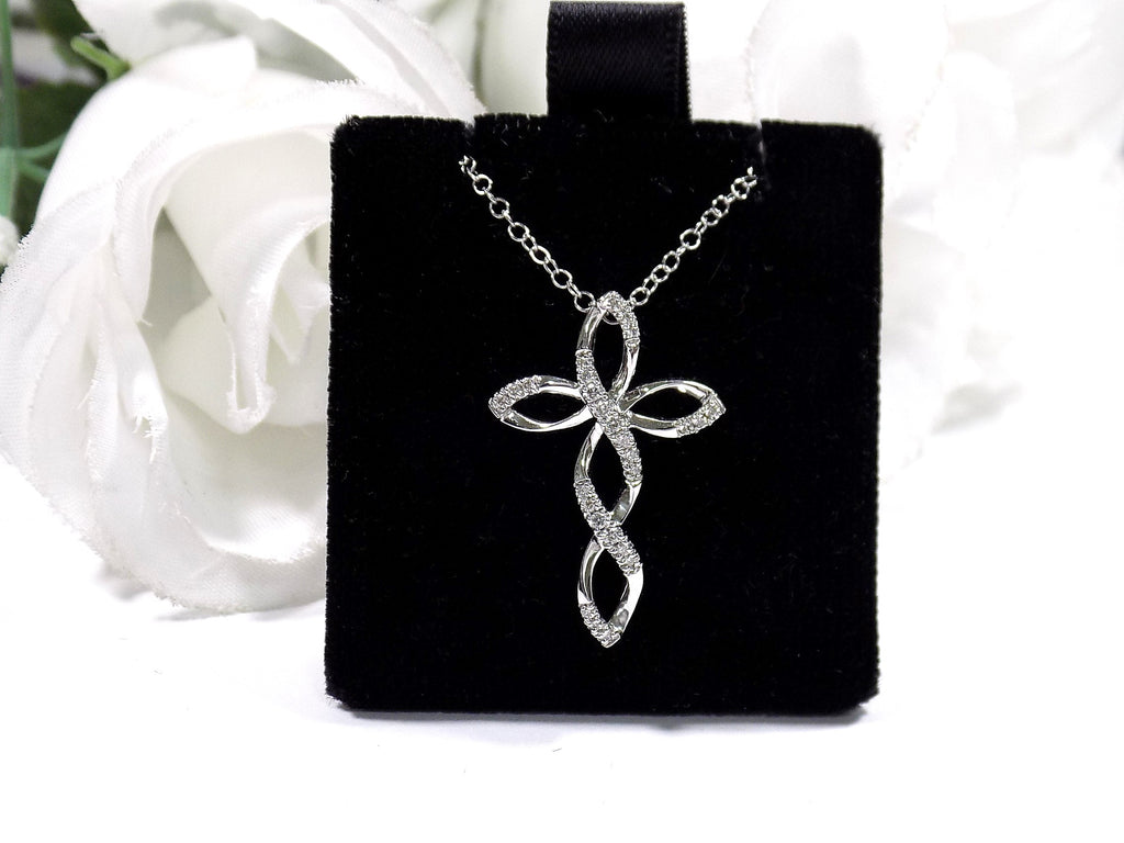 This is an infinity style natural diamond cross necklace in white gold.