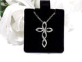 This is an infinity style natural diamond cross necklace in white gold.