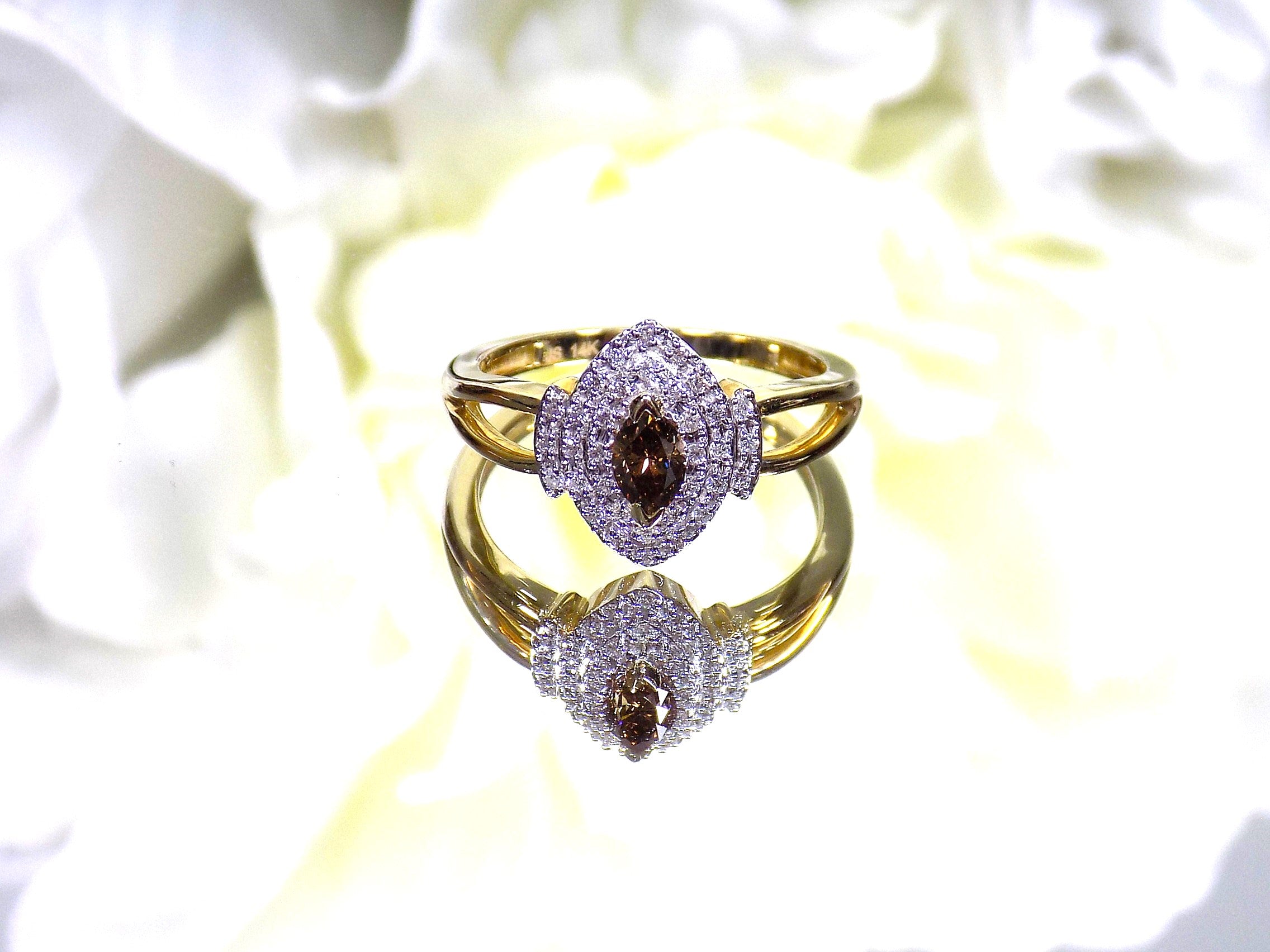 .50ct total weight with chocolate marquise center diamond and white round diamond accents in 2-tone white and yellow gold.