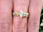 This is a .80ct total weight natural diamond ring baguette diamond accents in 2-tone 18K yellow gold and platinum shown on a woman's finger.