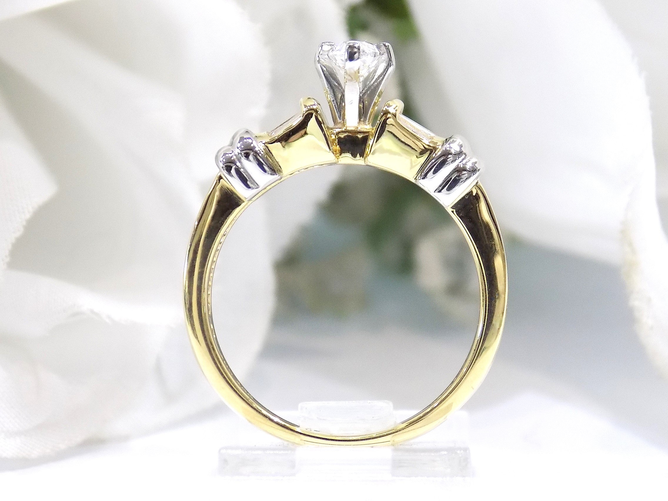 This is a side view of a .80ct total weight natural diamond ring baguette diamond accents in 2-tone 18K yellow gold and platinum shown with a white background.