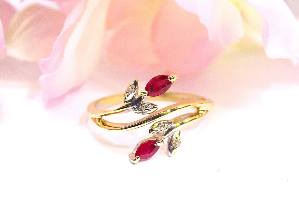 This is a .32ct total weight marquise shaped natural ruby and diamond ring in 10K yellow gold with a white and pink floral background.