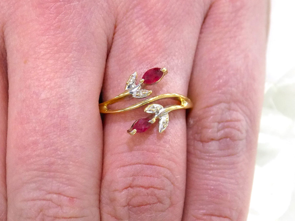 This is a .32ct total weight marquise shaped natural ruby and diamond ring in 10K yellow gold on a woman's finger.