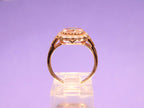 This is a women's ring with 1.94ct natural cushion cut morganite in the center surrounded by .30ct in natural round diamond accents in 14K rose gold  from a side view with a purple background.