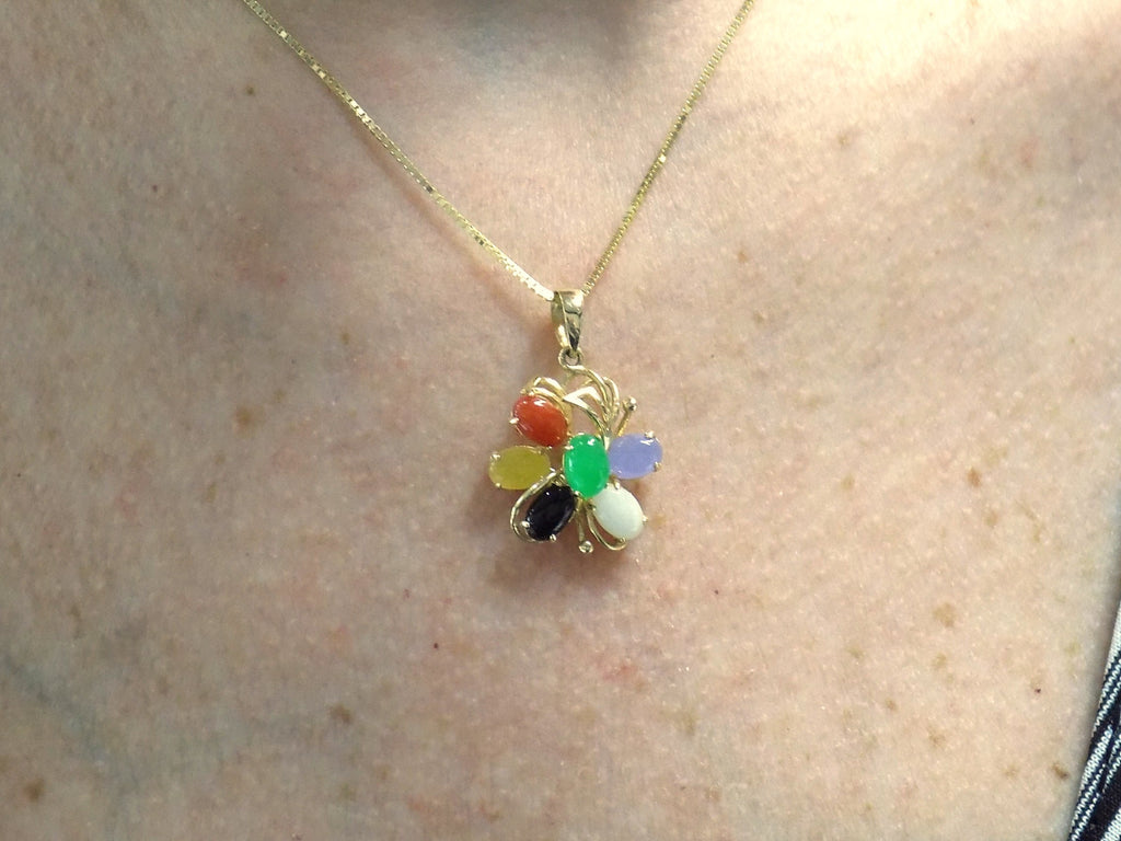 This is a fully restored to like new  multicolor jade & onyx pendant in yellow gold shown on a woman's neck.