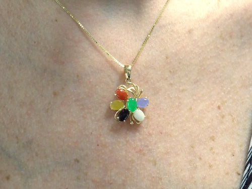 This is a fully restored to like new  multicolor jade & onyx pendant in yellow gold shown on a woman's neck.