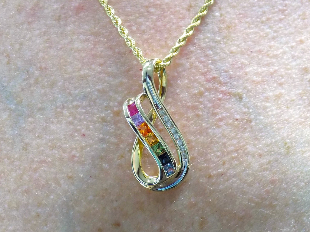 This is a women's slide pendant with 1.38ct total weight natural multicolor natural sapphires and .12ct total weight natural round diamonds in 14K yellow gold on a women's neck.