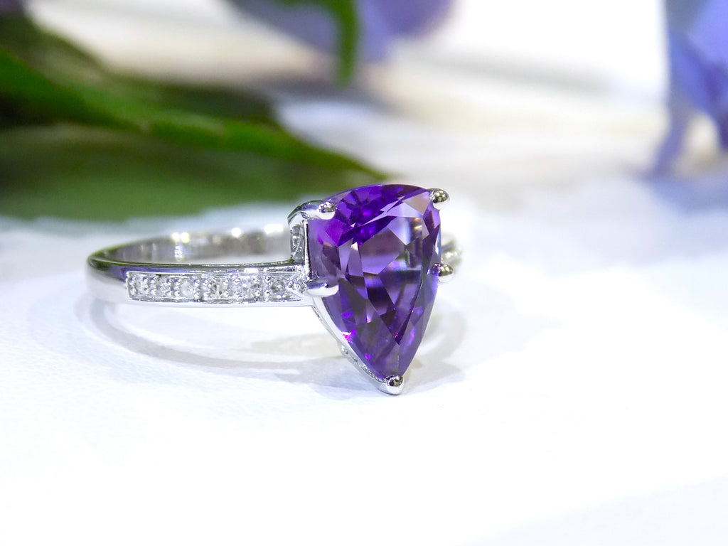 This is a 2.00ct natural amethyst and .06ct diamond ring in 14K white gold with a white and green background.