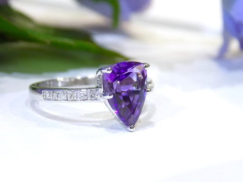 This is a 2.00ct natural amethyst and .06ct diamond ring in 14K white gold with a white and green background.