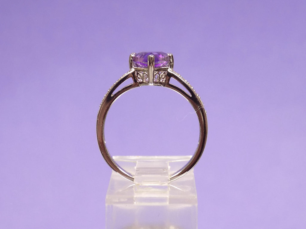 This is a 2.00ct natural amethyst and .06ct diamond ring in 14K white gold with a purple background.