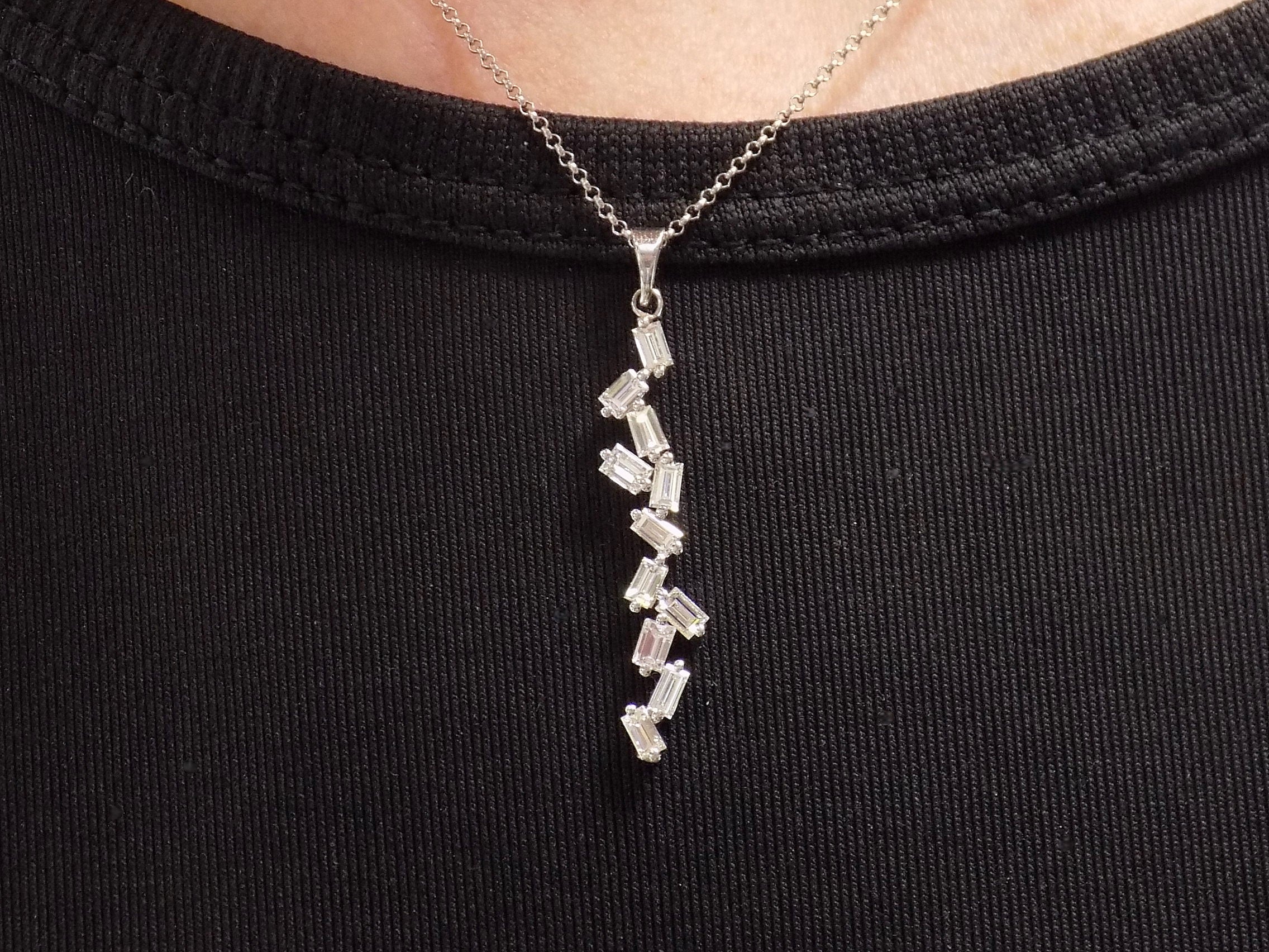 This is a custom made .91ct natural baguette diamond necklace in 18K white gold on a ladies neck with a black shirt.