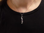 This is a custom made .91ct natural baguette diamond necklace in 18K white gold on a ladies neck with a black shirt.