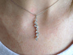This is a custom made .91ct natural baguette diamond necklace in 18K white gold on a ladies neck with a white shirt.
