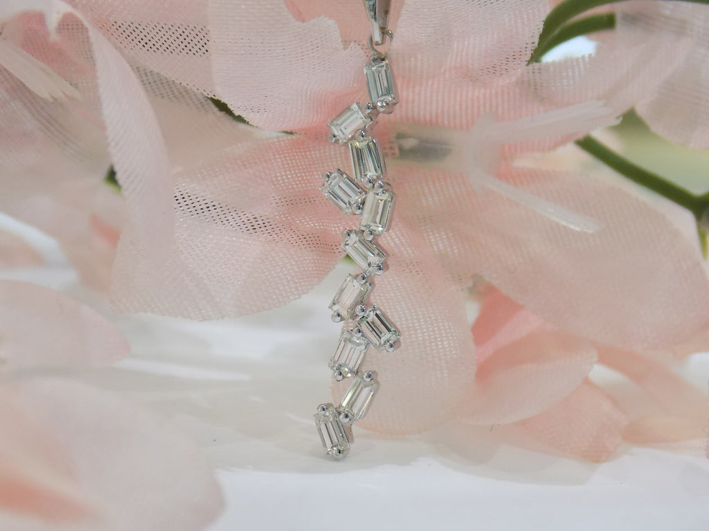 This is a custom made .91ct natural baguette diamond necklace in 18K white gold with a pink floral background.