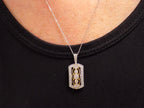 This is a .33ct natural diamond pendant that is a fiigree style in 2-tone white and yellow gold on a ladies neck with a black shirt.
