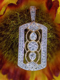 This is a .33ct natural diamond pendant that is a fiigree style in 2-tone white and yellow gold with a colorful background.