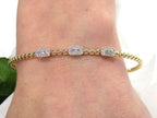.25ct natural emerald cut and round diamond flex bracelet in 10K yellow gold on a ladies wrist.