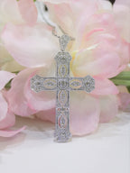 This is a .50ct natural diamond cross pendant with a very Victorian look in 10K white gold with a pink floral background.
