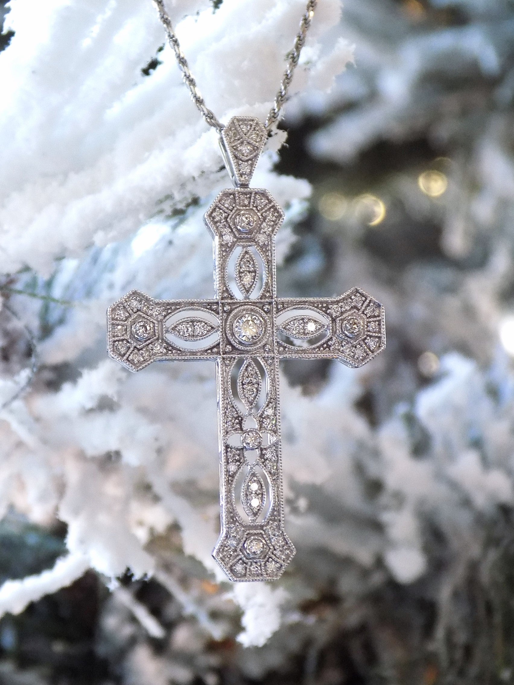 This is a .50ct natural diamond cross pendant with a very Victorian look in 10K white gold with a snowy looking background.