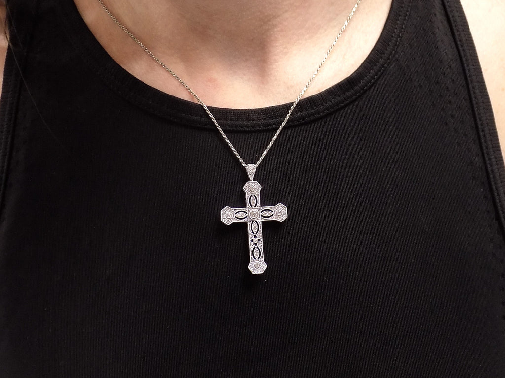 This is a .50ct natural diamond cross pendant with a very Victorian look in 10K white gold on a ladies neck with black shirt.