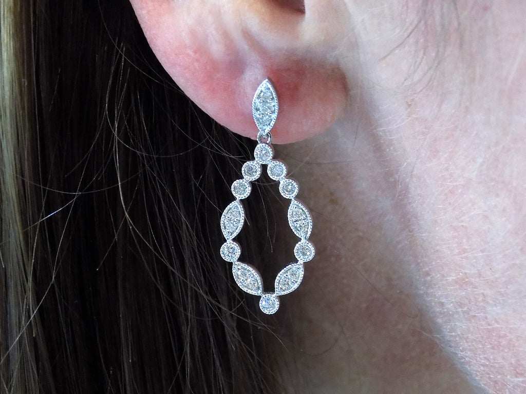 This is a pair of .50ct Natural Diamond Dangle Earrings in 14K White Gold in a woman's ear.