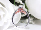 This is a side view of the engagement ring that goes with the halo style women's 2-piece wedding set highlighting the rose gold accents on the side with princess cut center weighing .88ct total in white gold with rose accents shown with white background.