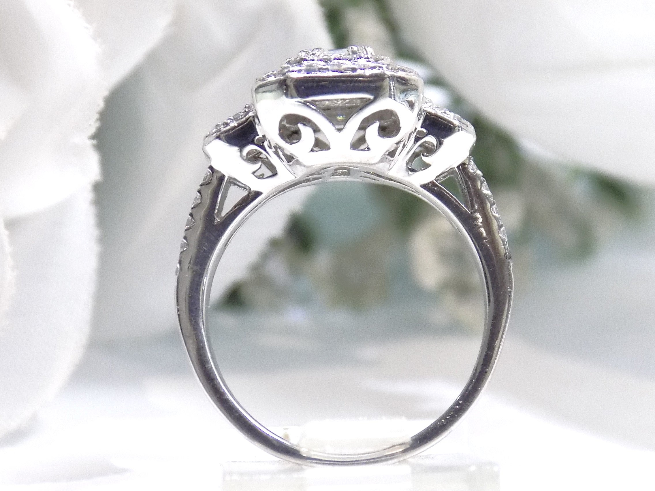 This is a side view of a 1.56ct total weight natural emerald cut and round diamond ring in platinum shown with a white background.