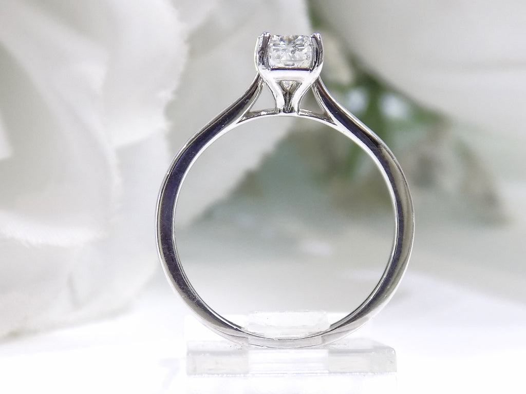 This is a side view of women's 1.00ct natural radiant cut diamond solitaire ring in white gold with a white background.