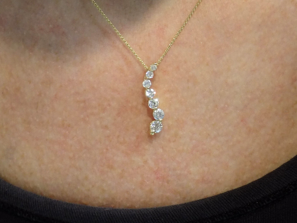 This is a vintage natural diamond journey style necklace in yellow gold on a ladies neck.