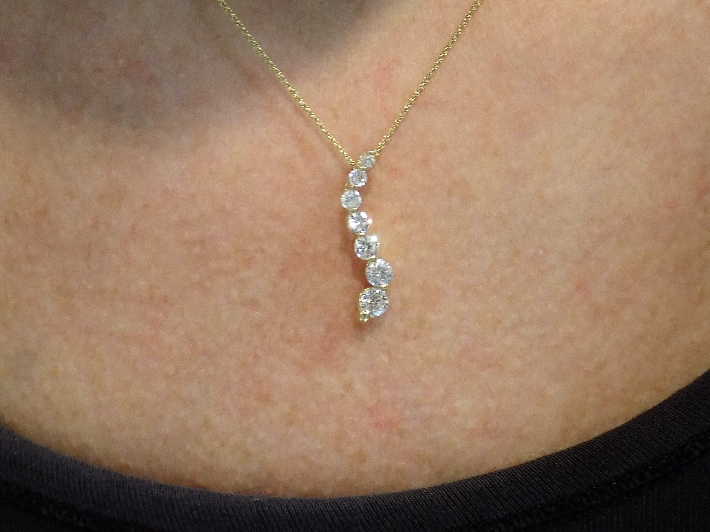 This is a vintage natural diamond journey style necklace in yellow gold on a ladies neck.