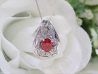 This is a vintage Victorian style women's oval (pigeon blood) natural 1.05ct ruby with .15ct natural round diamond accents in platinum with a white and green floral background.