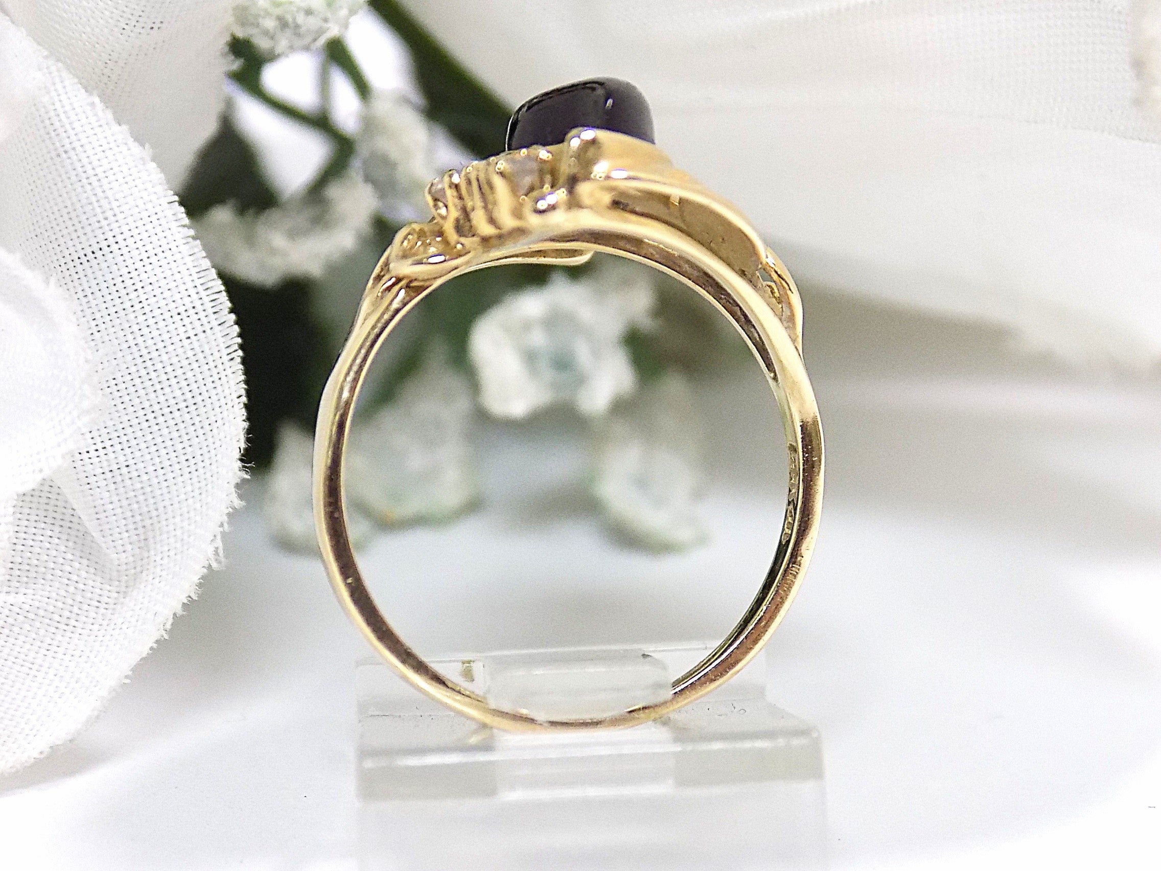 This is a side view of genuine black onyx and diamond ring in yellow gold from our estate collection in like NEW condition on a white background.