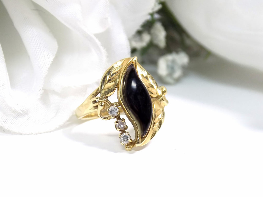 This is a genuine black onyx and diamond ring in yellow gold from our estate collection in like NEW condition on a white background.