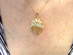 The is a genuine oval shape opal basket pendant in yellow gold from our estate collection in like new condition shown on woman's neck.